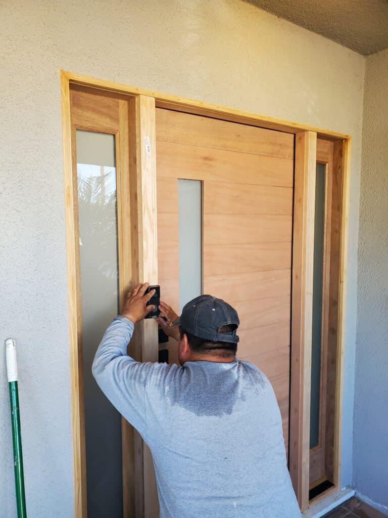 making final adjustments during solid wood door installation in Long Beach