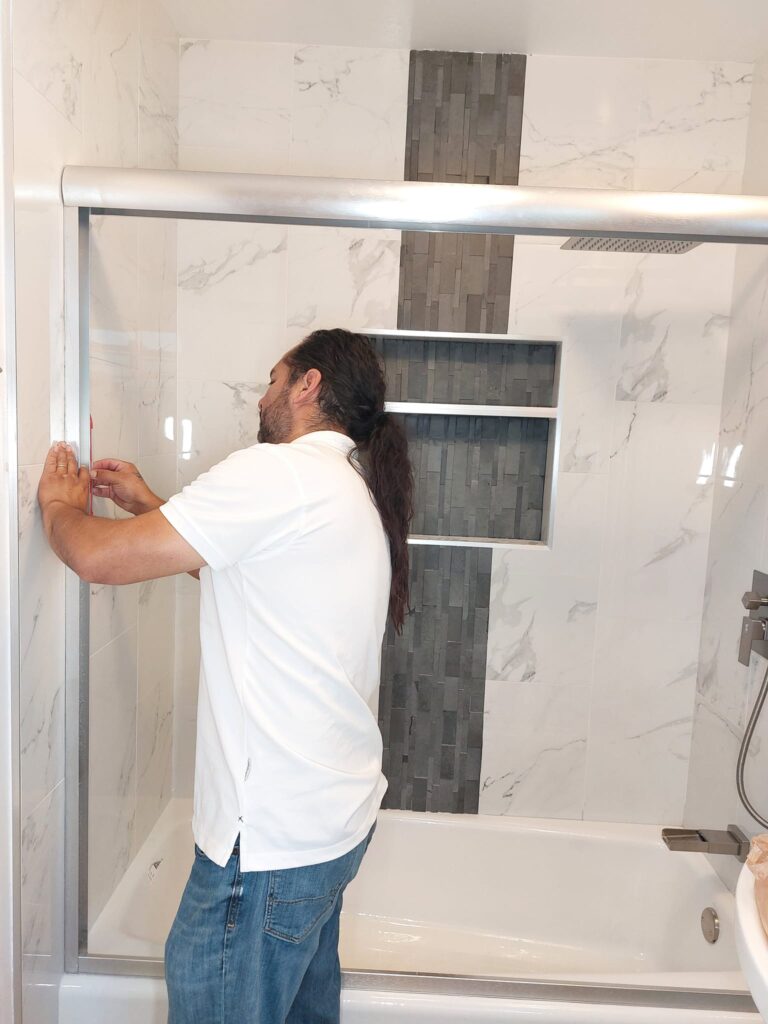 George installing a sliding shower door during a bathroom remodel in Long Beach