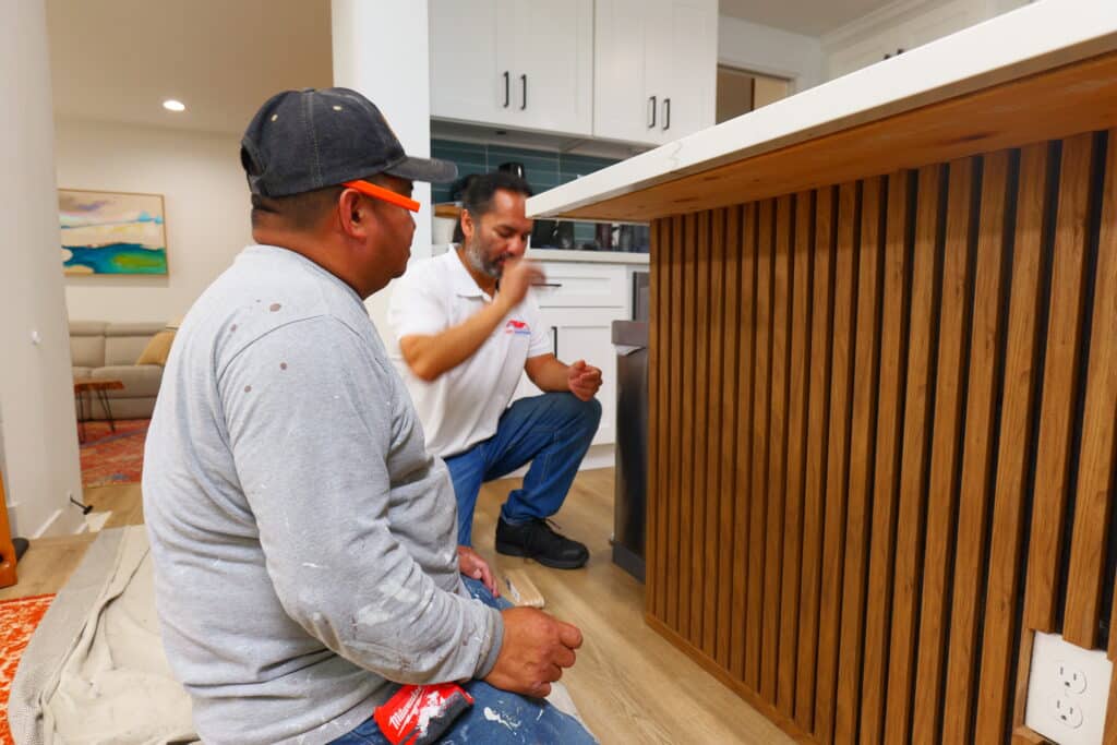 George and team installing stylish wood paneling for a kitchen island in Long Beach
