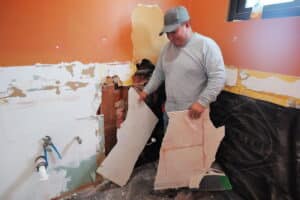 GR Repair & Maintenance team member removing damaged drywall during a home repair project